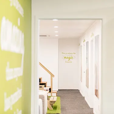 A view down the practice’s corridor, past the kids’ play corner to the treatment rooms