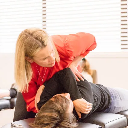 Dr Katie adjusting a patient with a cross-arm stretch