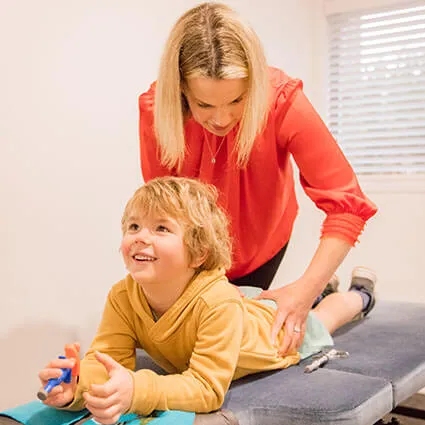 Dr Katie giving a lower back adjustment to a child patient