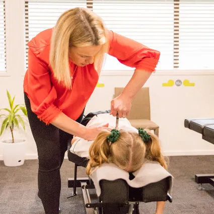 Dr Katie performing a manual neck adjustment on a child patient