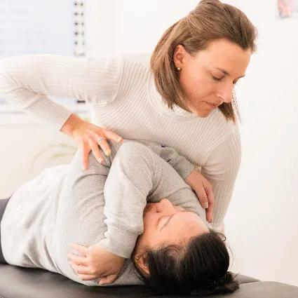 Dr Lydia adjusting a patient with a cross-arm stretch