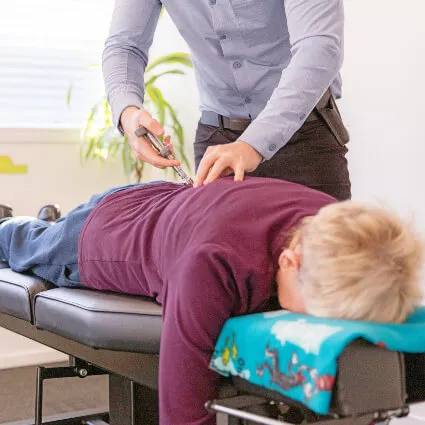 A chiropractor giving a patient a mid-back adjustment