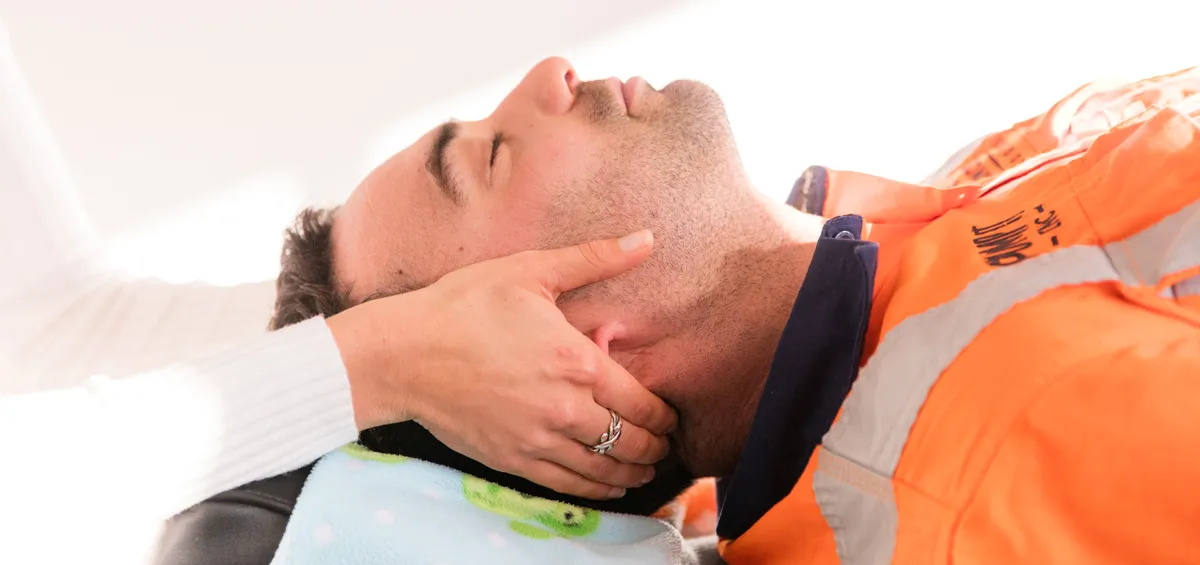 A chiropractor giving a patient a gentle neck adjustment