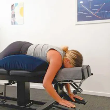 A woman lying on the chiropractic adjusting table