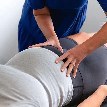 A pregnant woman receiving chiropractic treatment
